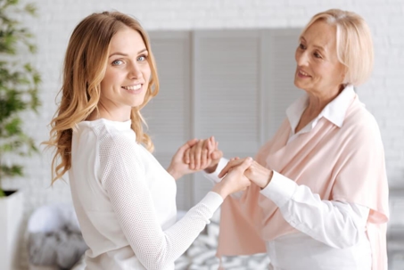 woman in white dress holding hands with another woman