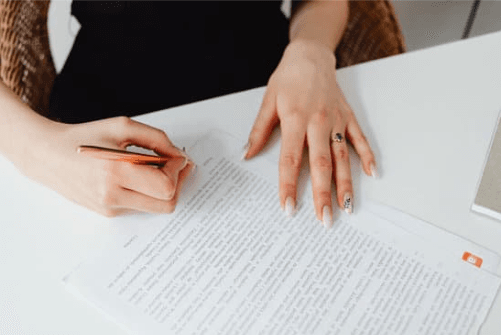 woman signing her name after divorce